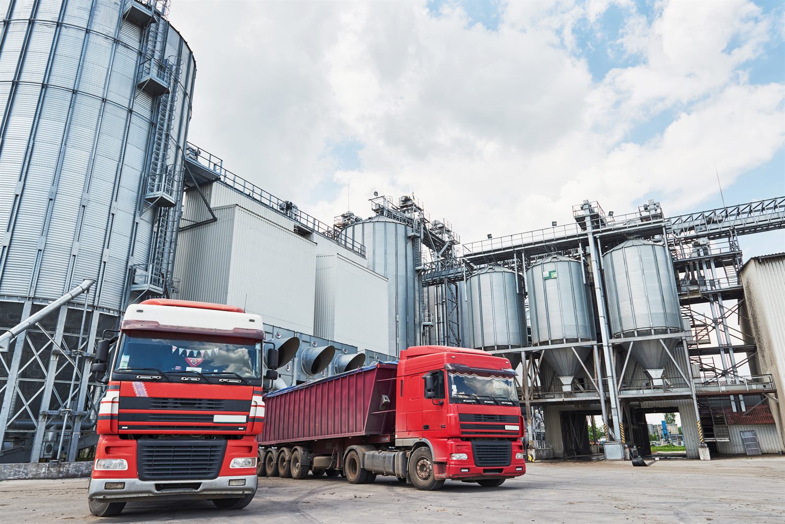 Caminhões graneleiros em silos de armazenagem